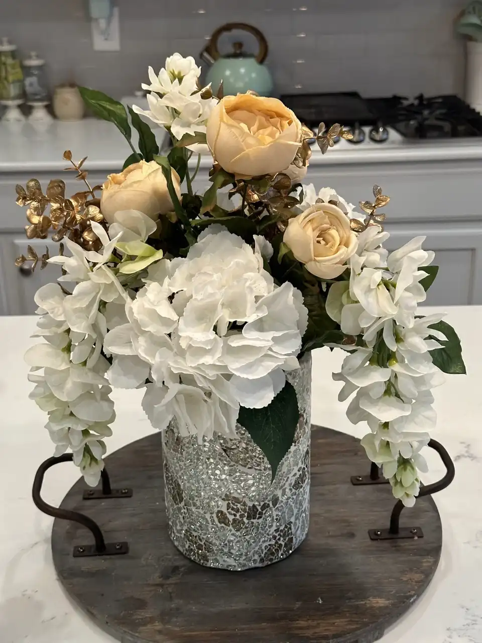 White hydrangea, cream roses and orchids in a mercury glass vase