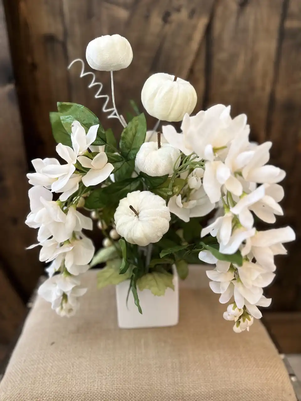 White pumpkins, cream orchids and wheat in a ceramic vase